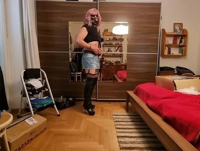 Jeans-Minirock, schwarze Stiefel, Strapse in Sicht...